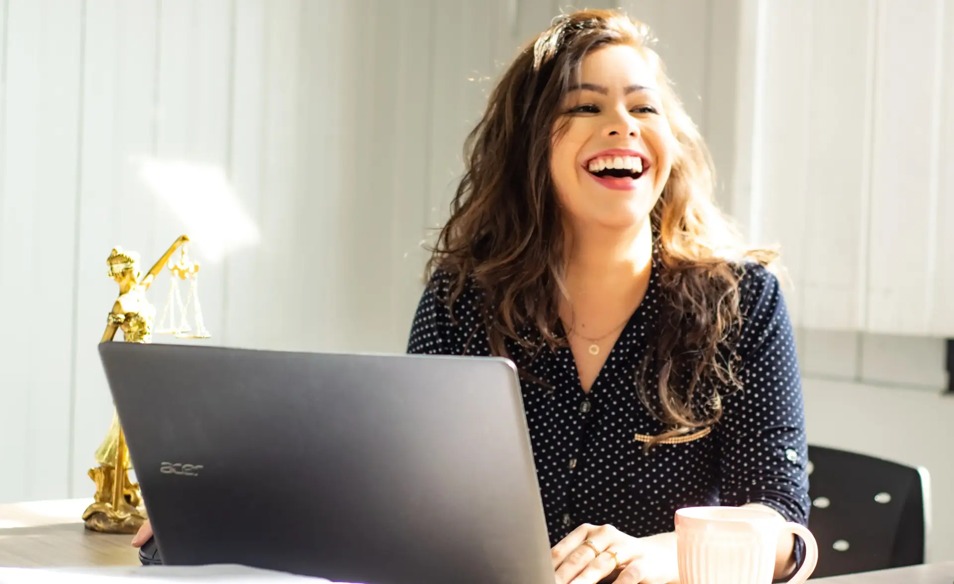 femme souriante utilisant un ordinateur portable.